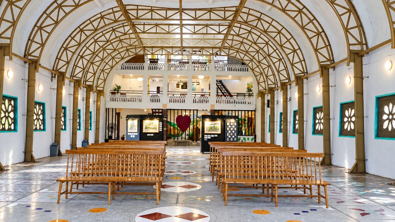 Wisata religi Magelang: ruang dalam Rumah Doa Bukit Rhema dengan bangku kayu dan rangka atap melengkung